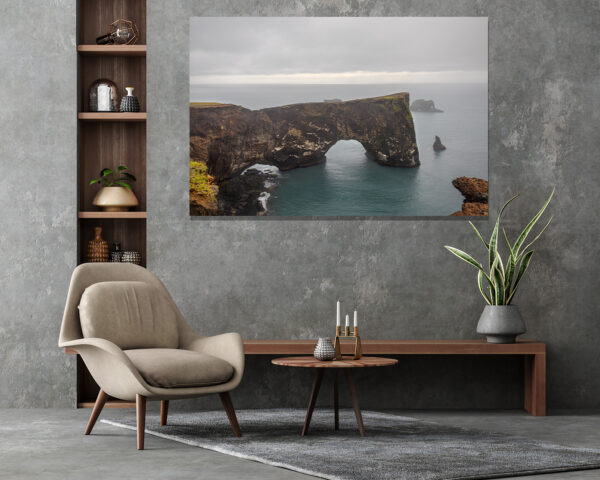 Wall decor photo of Dyrhólaey natural arch in Iceland showing black cliff and ocean under dramatic sky, perfect for Nordic interior decoration