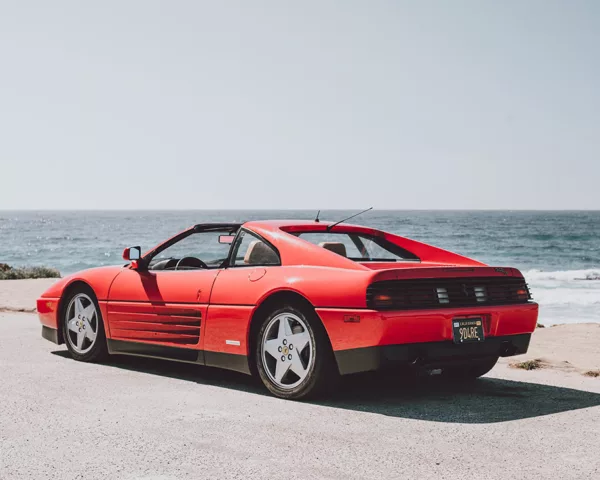 Ferrari 348 TS at Pebble Beach, 17-Mile Drive Red Ferrari 348 TS parked facing the ocean on 17-Mile Drive at Pebble Beach, California, rear three-quarter view