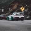 GT3rs et Bugatti Wall decor photo of white Porsche GT3 RS with teal wheels and black Bugatti Chiron on canyon road, perfect for luxury automotive interior decoration