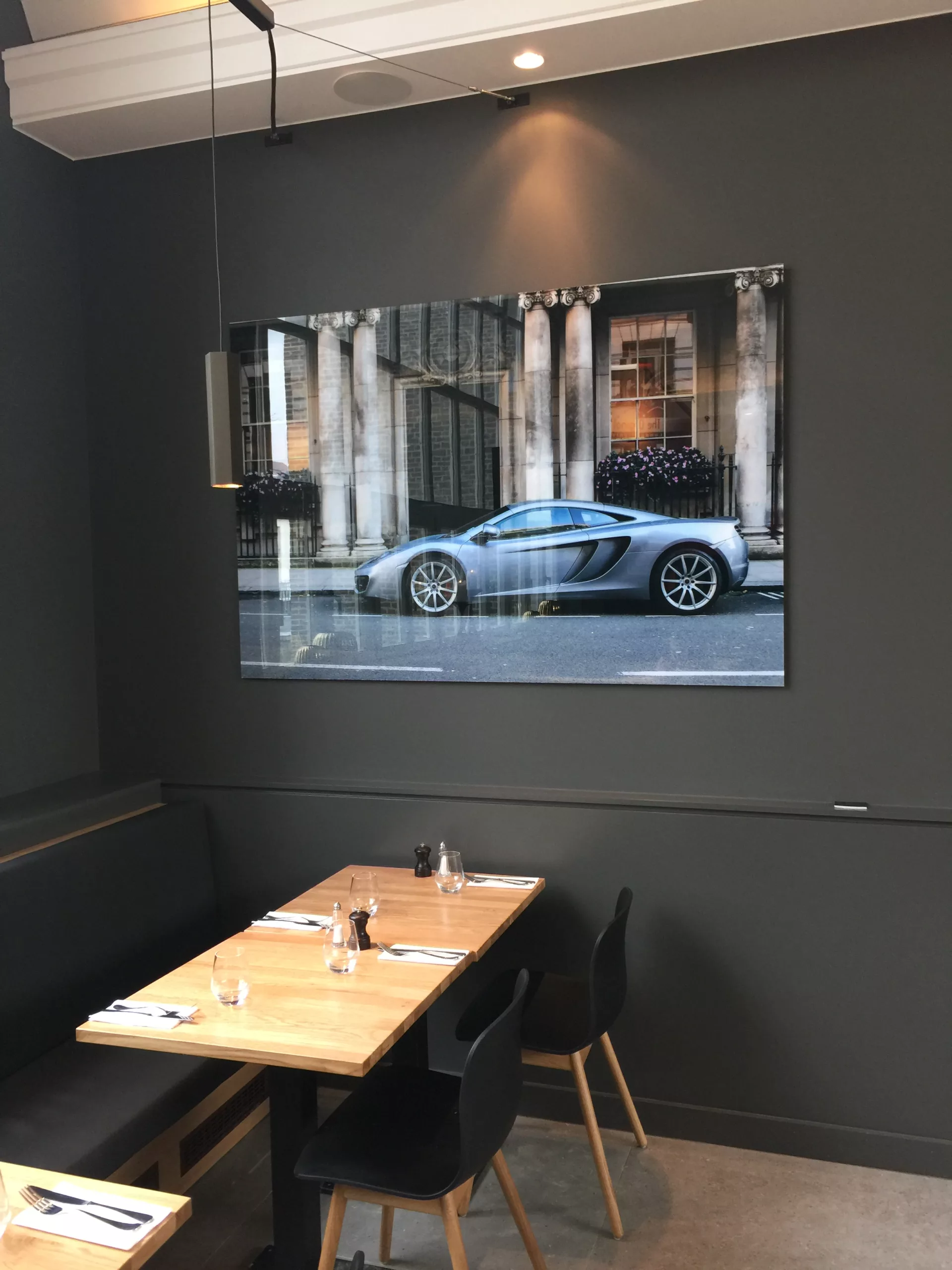 Car showroom with blue sports car and framed fine art print on a dark wall — Cars and Roses