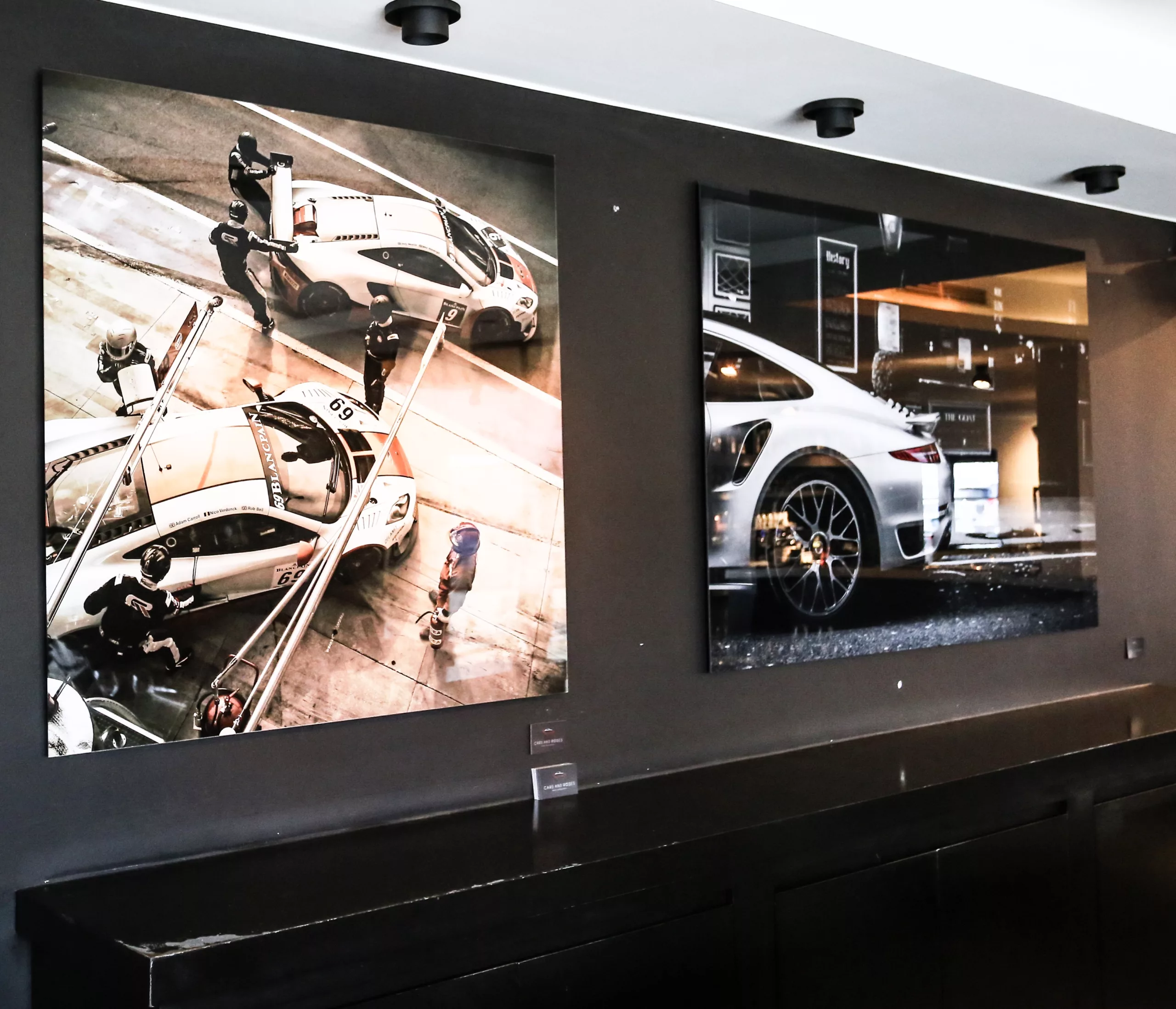 Car showroom with framed sports car fine art print, red accent wall — Cars and Roses