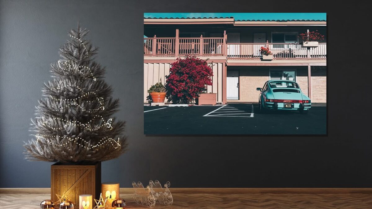 Wall art featuring a vintage turquoise Porsche parked in front of a building with red flowers, displayed in a festive interior with decorated Christmas tree and candles - Cars and Roses Christmas gift