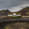 Solitary moss-covered restaurant in the volcanic highlands of northeast Iceland near Möðrudalsleið with dramatic mountains