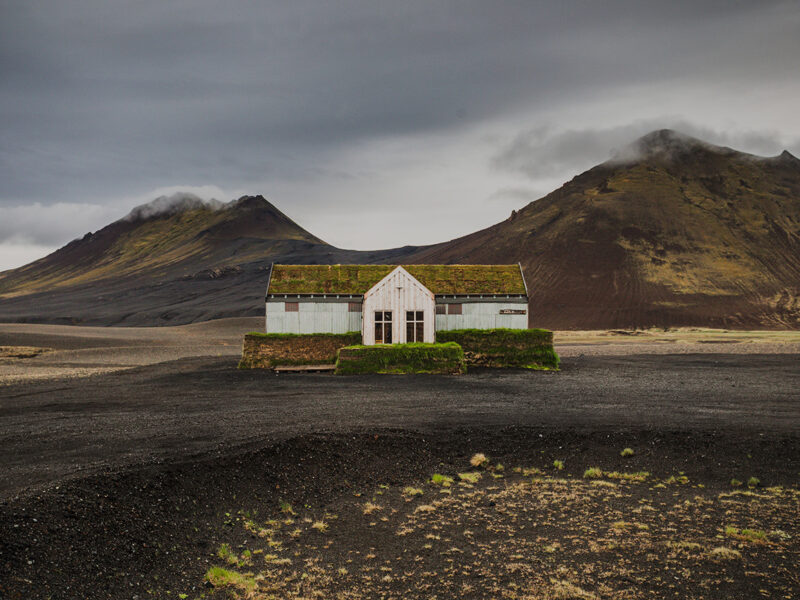 Solitary moss-covered restaurant in the volcanic highlands of northeast Iceland near Möðrudalsleið with dramatic mountains