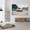White fireplace with wooden armchair Wall decor photo of classic orange Porsche 911 on winding coastal road followed by a turquoise Porsche, perfect for vintage automotive interior decoration