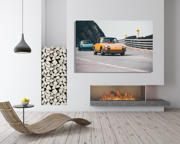 Wall decor photo of classic orange Porsche 911 on winding coastal road followed by a turquoise Porsche, perfect for vintage automotive interior decoration