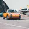 Photo Duo Porsche 911 Classic Pebble Beach Wall decor photo of classic orange Porsche 911 on winding coastal road followed by a turquoise Porsche, perfect for vintage automotive interior decoration