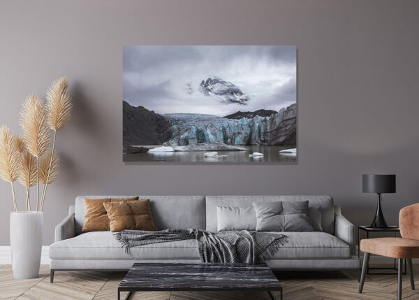 Dramatic landscape photograph of Svinafellsjökull Glacier in Vatnajökull National Park, Iceland, showcasing blue ice formations against dark mountains under a moody sky