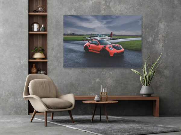 Photographs de la Porsche 911 GT3 RS – Énergie et Élégance Dynamic photograph of an orange Porsche 911 GT3 RS showcasing its aggressive aerodynamics, distinctive rear wing, and race-inspired design against a dramatic backdrop