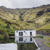 Photo de Seljavallalaug en Islande Iceland Seljavallalaug photography showing the historic 1920s mountain pool surrounded by towering cliffs and lush greenery in a remote Icelandic valley