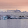Photographie Islande Glacier Sunset Wall decor photography of Jökulsárlón glacier in Iceland showing azure blue icebergs floating on the glacial lagoon under a pink twilight sky, perfect for Scandinavian interior design