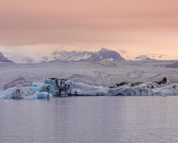 Wall decor photography of Jökulsárlón glacier in Iceland showing azure blue icebergs floating on the glacial lagoon under a pink twilight sky, perfect for Scandinavian interior design