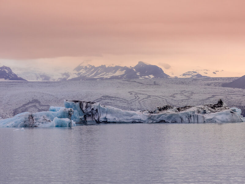 Wall decor photography of Jökulsárlón glacier in Iceland showing azure blue icebergs floating on the glacial lagoon under a pink twilight sky, perfect for Scandinavian interior design