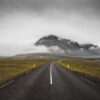 Photograph of Route 1 in Iceland – Majestic Landscape Dramatic landscape photograph of Iceland's Route 1 (Ring Road) winding through a vast, untouched wilderness with majestic mountains, moody skies, and the distinctive ribbon of highway cutting through rugged terrain