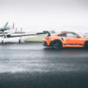 Piste Mouillée Wall ARt Porsche GT3 Rs Orange Porsche 911 GT3 RS on a wet airfield runway beside a light aircraft - fine art photography print