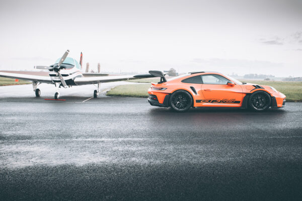 Piste Mouillée Wall ARt Porsche GT3 Rs Orange Porsche 911 GT3 RS on a wet airfield runway beside a light aircraft - fine art photography print