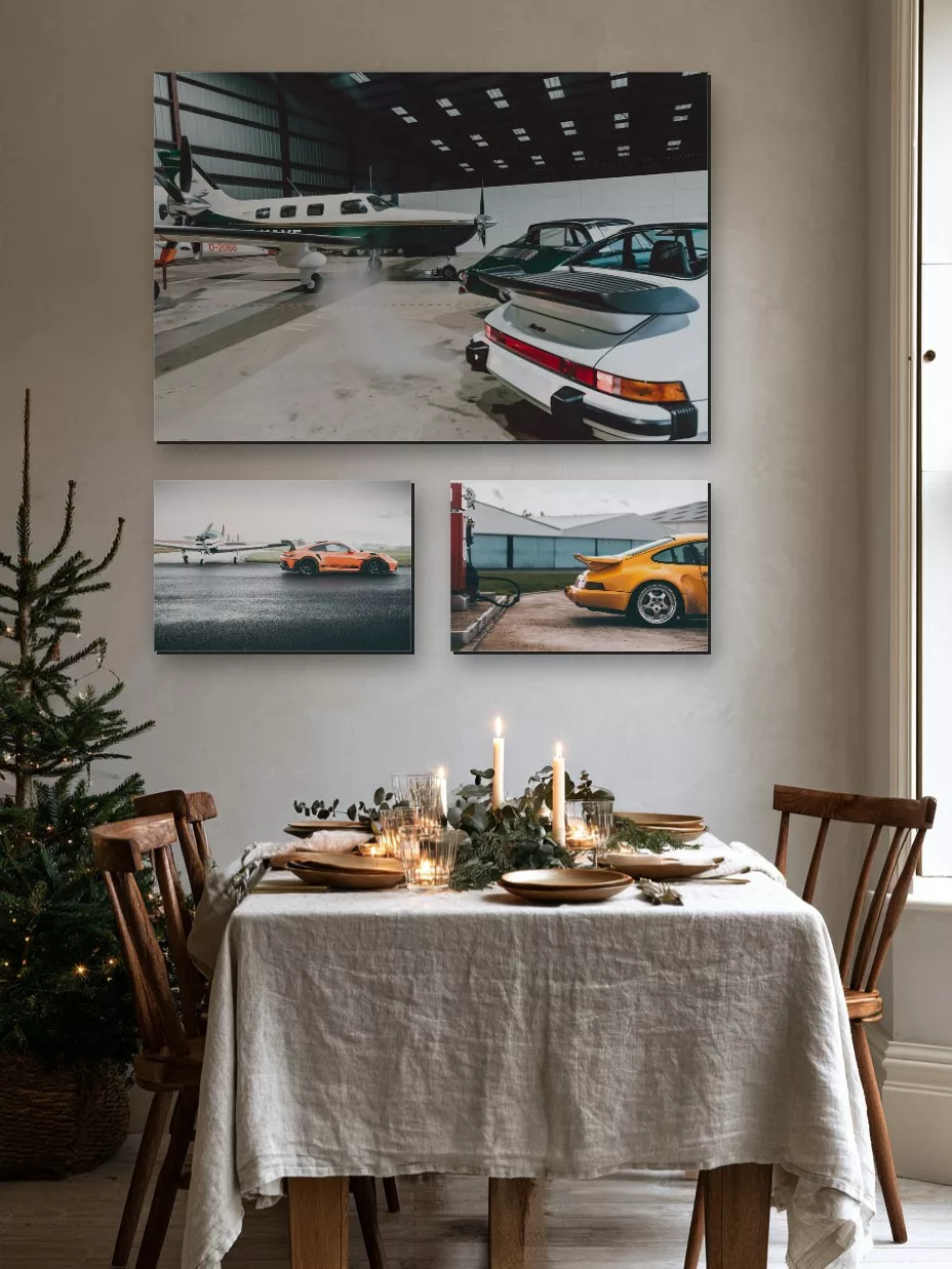 Three Porsche fine art prints above a Christmas dining table