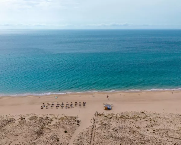 Zahara de los Atunes beach in Spain seen from above, with turquoise Atlantic water, golden sand and dunes