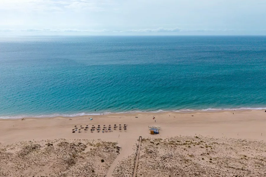 Zahara de los Atunes beach in Spain seen from above, with turquoise Atlantic water, golden sand and dunes